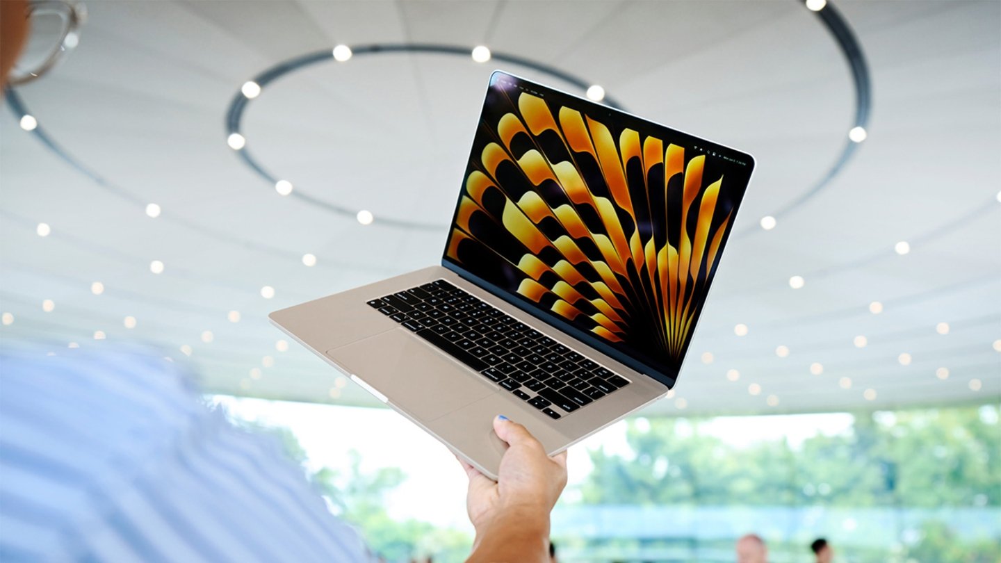 MacBook Air sostenido con una mano por un usuario