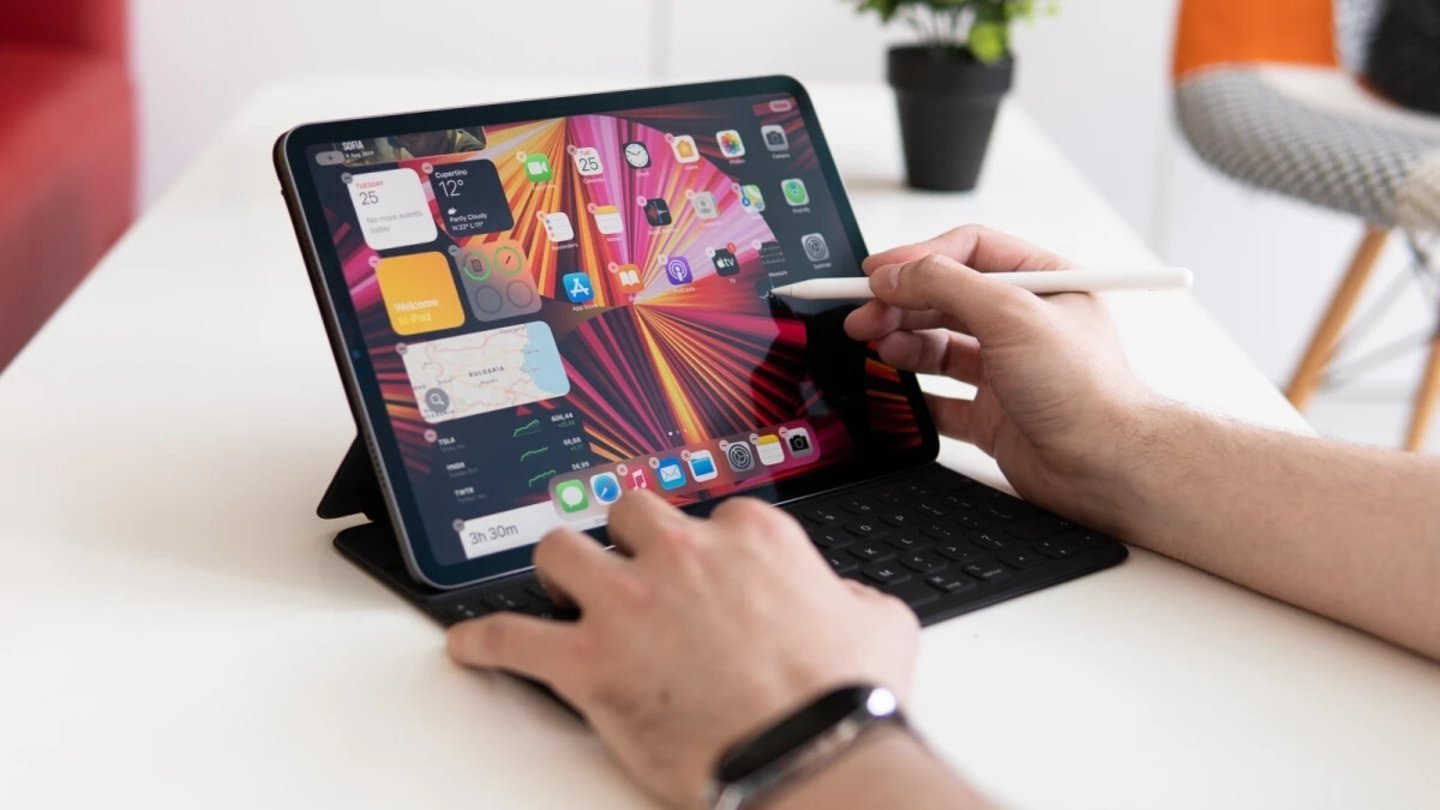 iPad Pro com chip M1 e teclado, com usuário usando Apple Pencil
