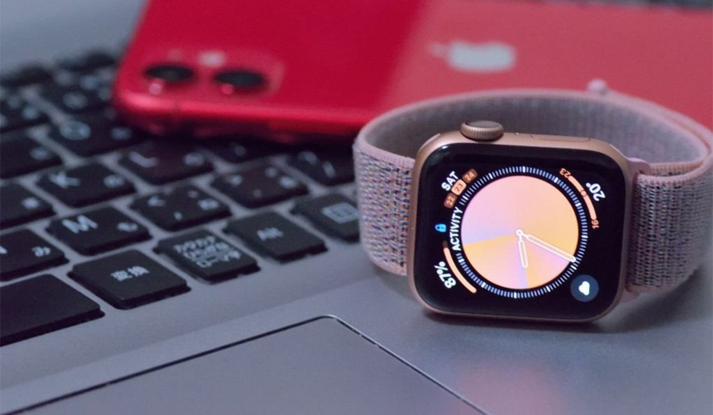Apple Watch sobre un Mac con un iPhone de fondo