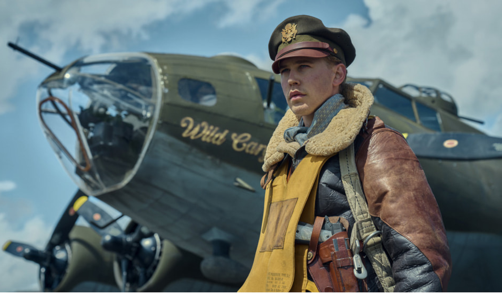 Austin Butler protagonista de “Masters of the Air” Apple TV+, vestido de piloto al lado de un avión