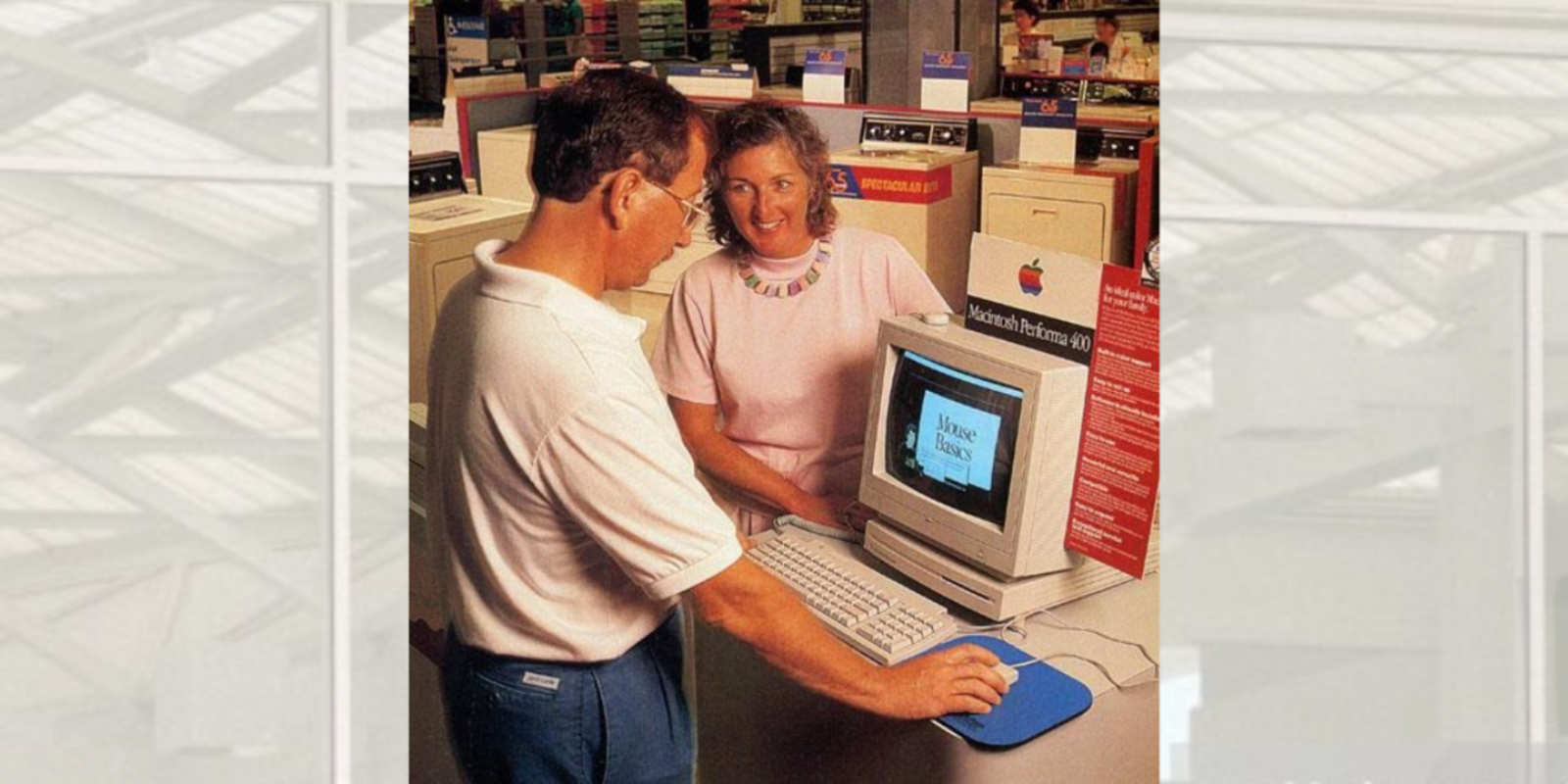 Un hombre y una mujer en una tienda frente a un Mac en la década de los 90
