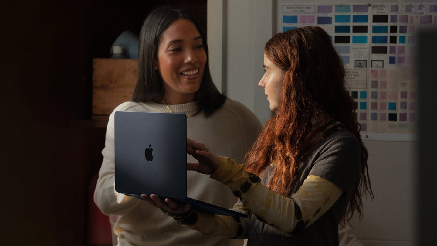 Una mujer y una niña con un MacBook de Apple